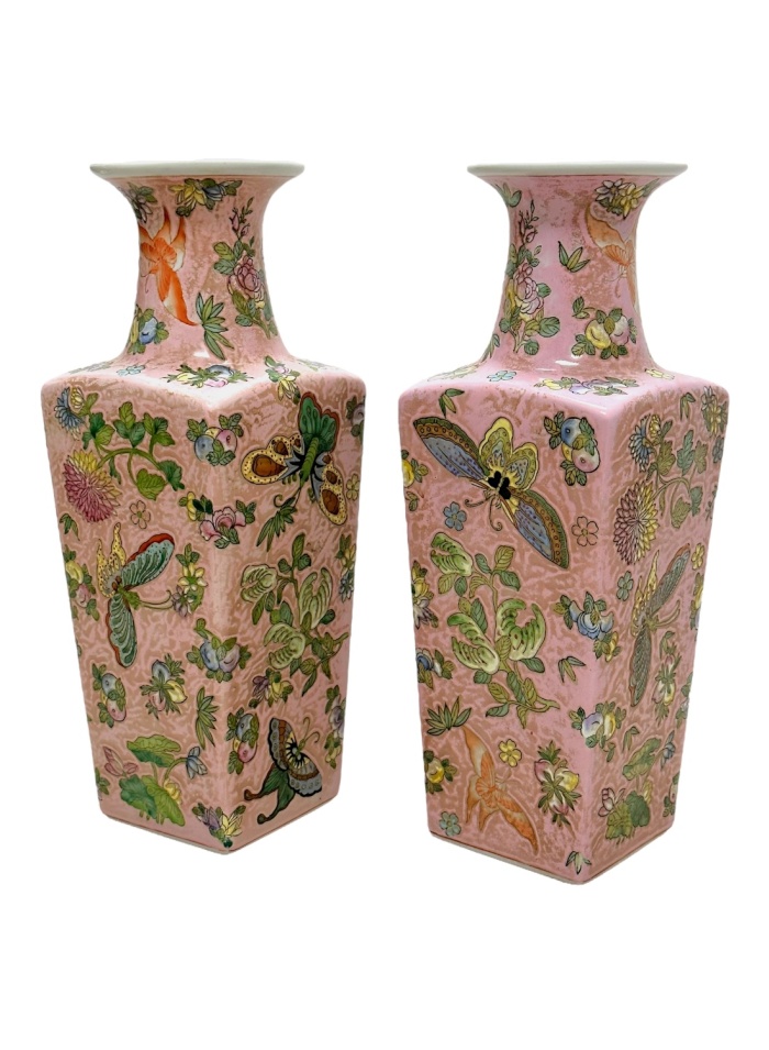 Close-up of vintage pink Chinoiserie vases featuring butterfly, fruit, and floral motifs.
