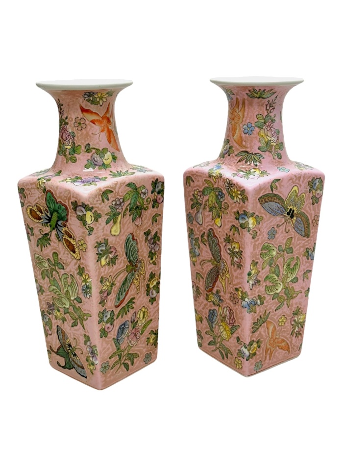 Side by side view of vintage pink chinoiserie vases featuring floral and butterfly motifs.