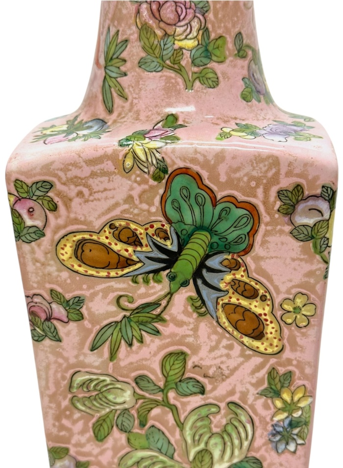 Close-up of vintage pink chinoiserie vases featuring intricate fruit, flower, and butterfly motifs.