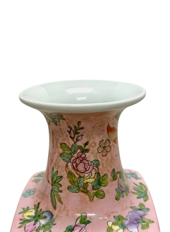 Close-up of vintage pink chinoiserie vase with floral motif and gold accents.