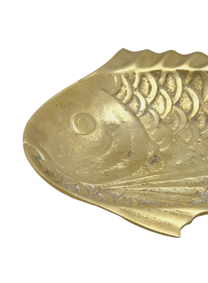Close-up of vintage brass fish dish, intricate details accentuate its charm.